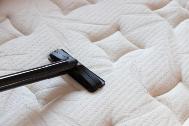 vacuuming a mattress to remove allergens