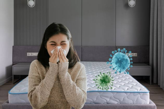 woman sneezing from allergens in mattress